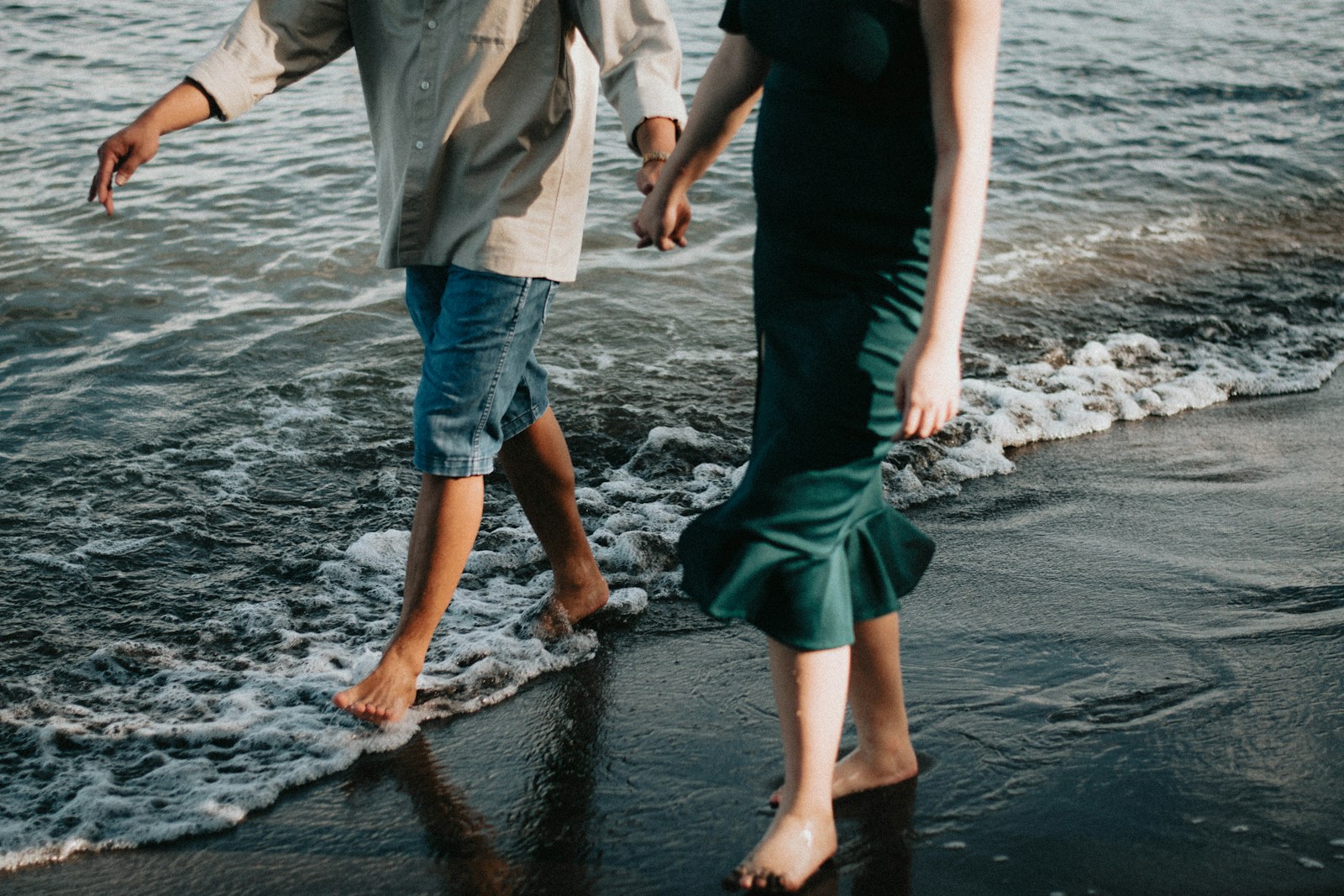 Un homme et une femme marche sur la plage en se tenant la main, l'hypnose les détend.